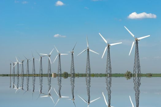 Natural landscape with windmills reflected in the water.