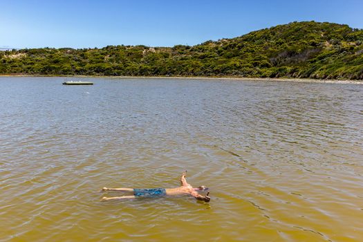 Man floating like dead in a salt sea with thumbs up, south Australia.