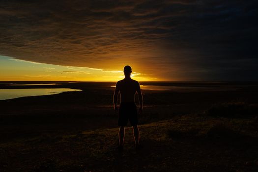 silhouette of a jung man enjoying beautiful sunset in the australian outback with 3 lakes, Gladstone scenic lookout