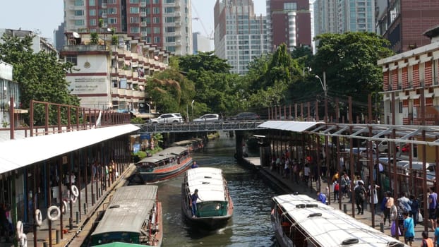 BANGKOK, THAILAND - 18 DECEMBER, 2018 Pratunam pier, express boat public transport stop in center of city. Saen Saep canal. Busy traffic on Ratchadamri road