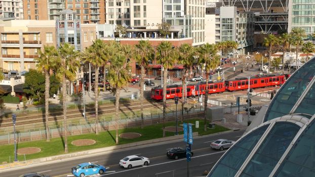 SAN DIEGO, CALIFORNIA USA - 30 JAN 2020: MTS red trolley and metropolis urban skyline, highrise skyscrapers in city downtown. From above aerial view, various buildings in Gaslamp Quarter and tram.