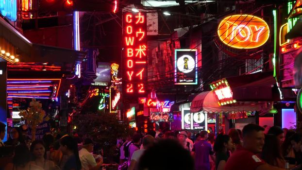 BANGKOK, THAILAND,13 JULY 2019: Vivid neon signs glowing on Soi Cowboy street. Nightlife in erotic Red light district. Illuminated bar and adult go-go show club. Night life tourist entertainment.