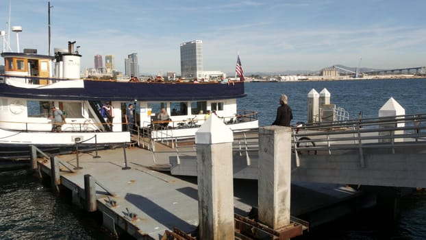 SAN DIEGO, CALIFORNIA USA - 30 JAN 2020: Silvergate passenger ferry boat near pier, Coronado island landing, Flagship public transportation. Metropolis urban skyline, highrise skyscrapers near harbor.