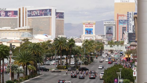 LAS VEGAS, NEVADA USA - 7 MAR 2020: The Strip boulevard with luxury casino and hotels in gambling sin city. Car traffic on road to Fremont street in tourist money playing resort. People walking.