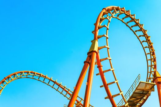 close-up image of a rollercoaster track and the blue sky