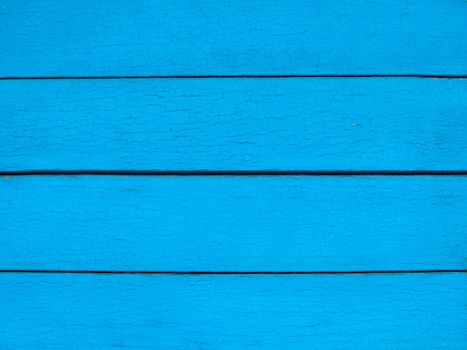 The wall is made of planks with a textured surface of light blue color.Texture or background