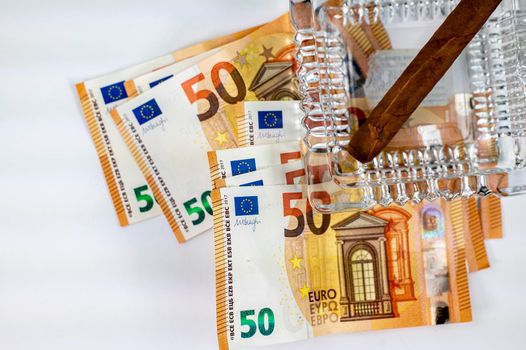 50 euro bills with cigar and ash holder on white background