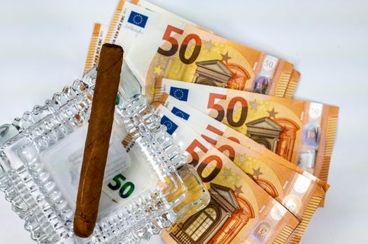 50 euro bills with cigar and ash holder on white background
