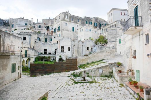Matera, an ancient courtyard carved into the rock and the houses also dug into the mountain