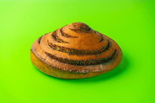 bun with poppy seeds on a green background close-up. isolate. High quality photo