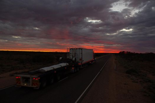 NORTHERN TERRITORY, AUSTRALIA - APRIL 12, 2010: Roadtrains in desert in Northern Territory on April 12, 2010, Australia. A roadtrain use in remote areas of Australia to move freight efficiently.