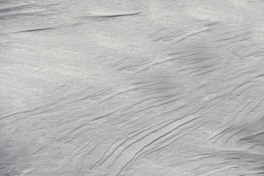 Winter background of freshly fallen snow in clear sunny weather with a textured surface.Texture or background