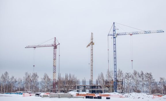 High-rise crane for construction on the sky background. Construction site with high-rise cranes. Sale of a tower crane during the economic crisis.