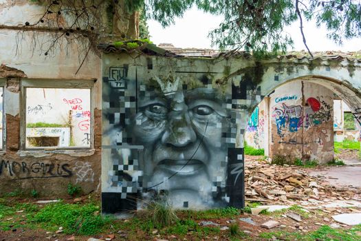 Villa Levidi, Pallini, Greece - February 14, 2021: Abstract face wall painting at an abandoned old villa at Pallini, Greece