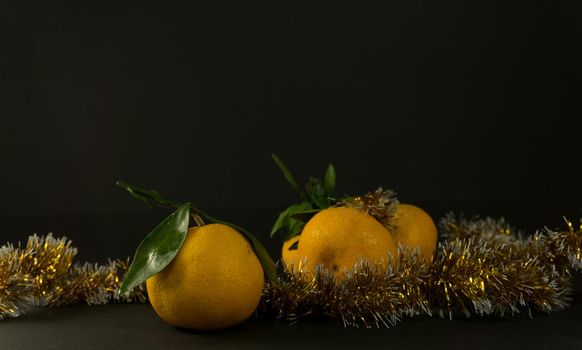 Tangerine cut with a green leaf on black background