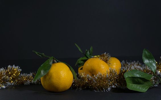 Tangerine cut with a green leaf on black background