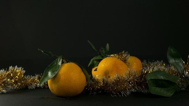 Tangerine cut with a green leaf on black background