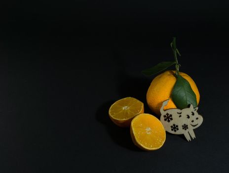 Tangerine cut with a green leaf on a black background Goby symbol of 2020