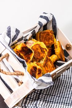 Freshly baked homemade ham and cheese puff pastry in a rustic crate.