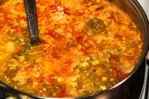 Preparation of soup with chicken and vegetables. Close up of boiling soup.