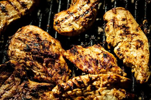 Chicken and pork steak grilled on a charcoal barbeque. Top view of camping tasty barbecue, food concept, food on grill and detail of food on the grill