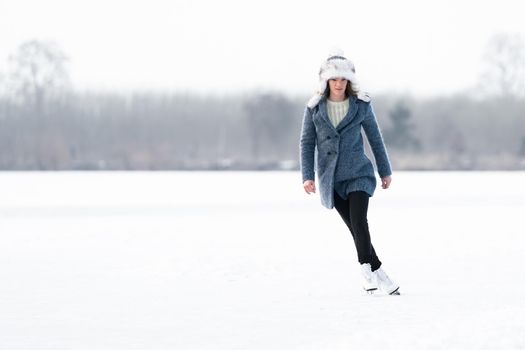 ice skating on the ice of a frozen lake young attractive woman.