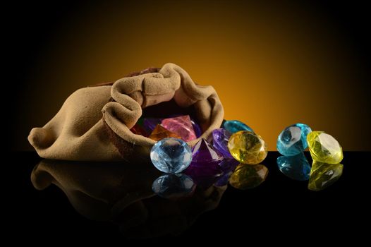 A spilling pouch of gemstones over a dark gradient background.