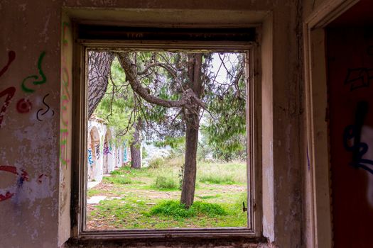 Villa Levidi, Pallini, Greece - February 14, 2021: Window view of an abandoned old villa at Pallini, Greece