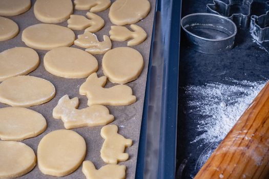 Rolling pin and kitchenware for making easter cookies on dark background.