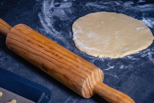 Rolling pin and kitchenware for making easter cookies on dark background.