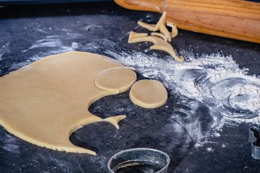 Rolling pin and kitchenware for making easter cookies on dark background.