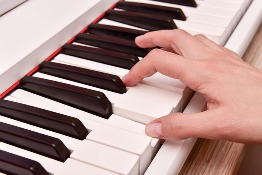 Woman's hands playing electronic digital piano at home. The woman is professional pianist arranging music using piano electronic keyboards. Musician practicing keyboard composing music.