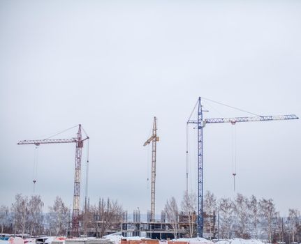 High-rise crane for construction on the sky background. Construction site with high-rise cranes. Sale of a tower crane during the economic crisis.