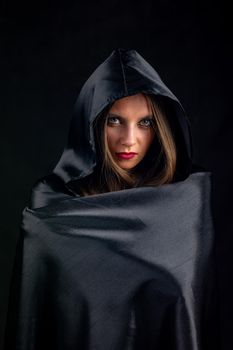 Portrait of a girl in a silk black cloak