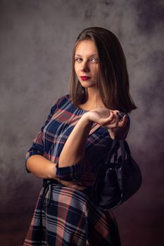 Portrait of a beautiful girl with a black handbag in her hands