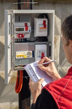 The gardener takes control readings of electricity meters