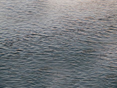 Sea water small waves close-up dark blue color.Texture or background