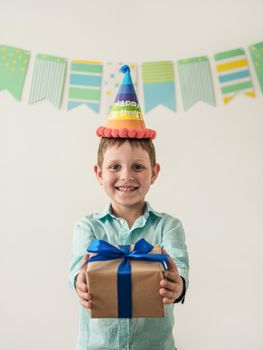 Five year old boy in his birthday hold gift box. Happy little child hold gift box with present and looking at camera
