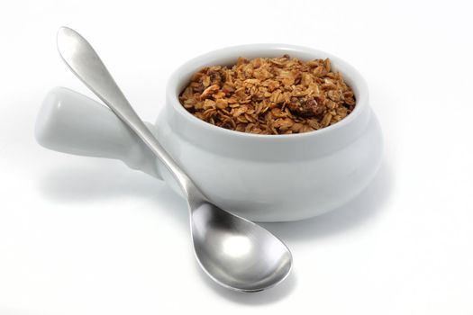 A bowl of granola and spoon on white