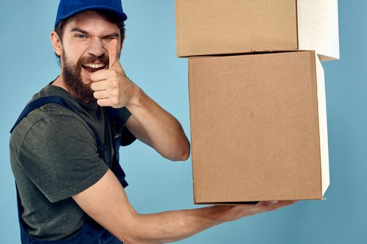 man with boxes service delivery uniform working blue background. High quality photo