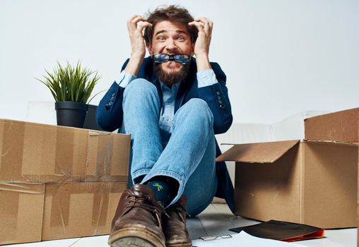 Emotional male manager unpacking lifestyle boxes in office. High quality photo