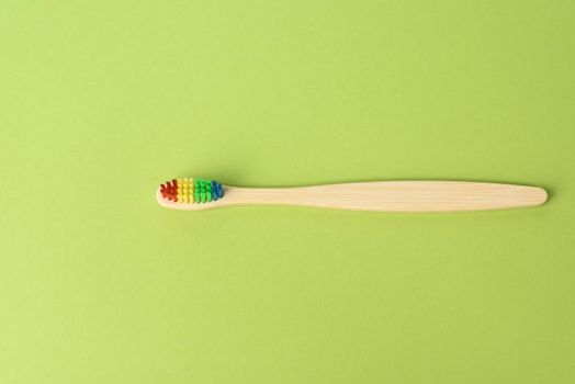 wooden toothbrush on green background, zero waste, top view