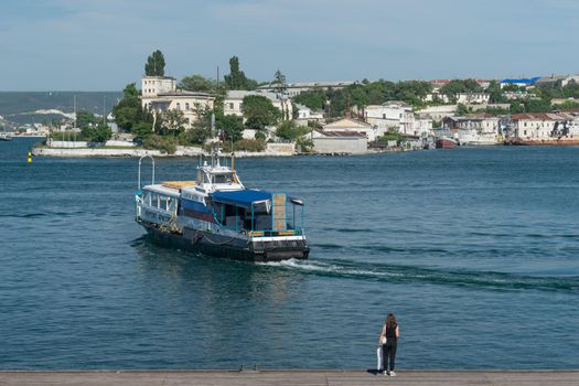 Sevastopol, Crimea. Pleasure boat on the background of the sea and the urban landscape.