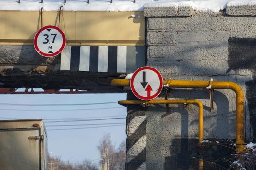 road signs under railroad bridge over road - yield and 3 meter maximum height.