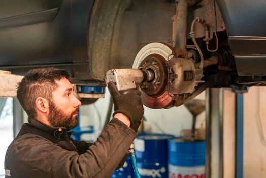 Mechanic performs maintenance on the car in the workshop