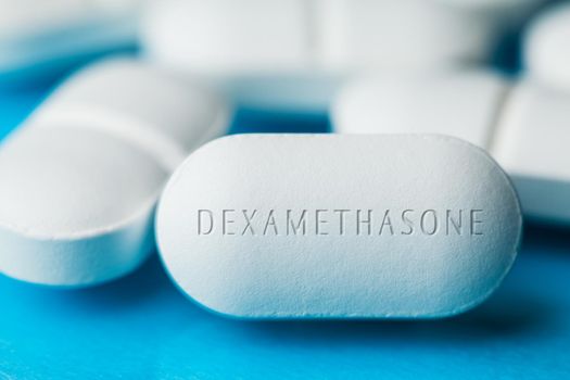 COVID-19 corticosteroid medication drug DEXAMETHASONE,pile of white pills with letters engraved on side,potential experimental WHO Coronavirus cure,pandemic outbreak crisis,US antiviral clinical trial