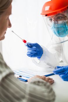 COVID-19 rt-PCR test procedure,medical worker in PPE wearing hazmat suit,face shield & mask,swabbing female patient,nasal nasopharyngeal specimen collection for detecting Coronavirus disease infection