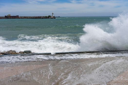 Yalta, Crimea. Embankment of the city during a storm and people on the background of waves.
