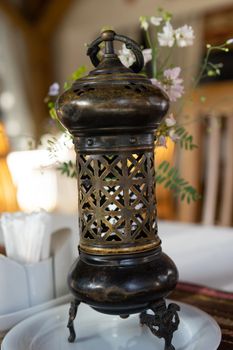Beautiful metal lamp with ornament on a blurred background