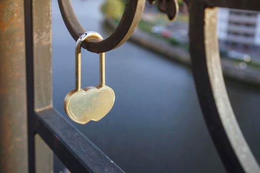 Metal lock symbol of love on the metal fence of the bridge